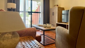 Un salon moderne comprenant un canapé, une table basse, un téléviseur et un meuble.