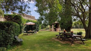 A patio area with a table and chairs, a barbecue grill, and a pergola with a canopy. - More Riera SPECTACULAR FARMHOUSE near Besalú for 13 people (Maià de Montcal)