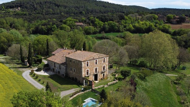 A large stone building with a tiled roof, surrounded by lush greenery and a small pool. - More Riera SPECTACULAR FARMHOUSE near Besalú for 13 people (Maià de Montcal)