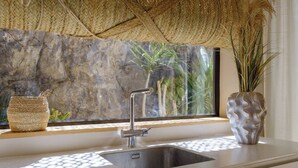 A modern kitchen with a stainless steel sink, a woven basket, and a decorative vase. - Hot Tub, sea, wifi pro, gas barbecue, garden, 11 (San Miguel de Abona)