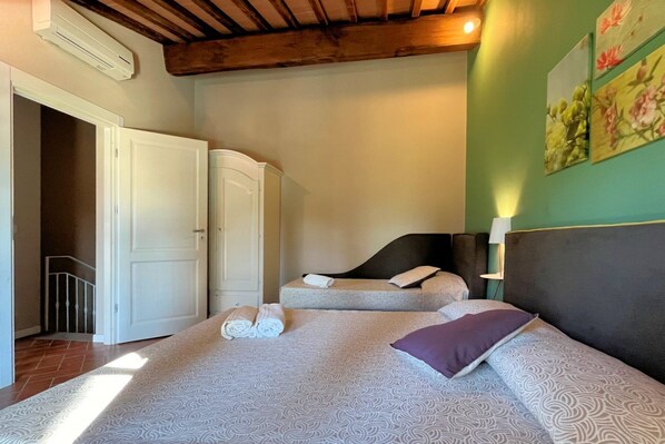 Un dormitorio con dos camas, un armario y una puerta que da a una escalera.