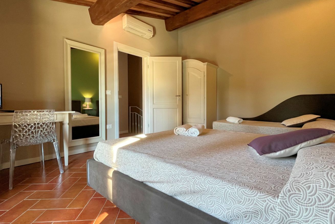 A bedroom with a bed, a desk, and a chair.