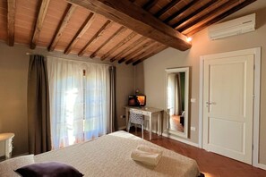 Une chambre à coucher avec un lit, un bureau, une chaise et un téléviseur.