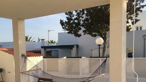 An outdoor patio with a table and chairs, a hammock, and a white fence. - SES SIVINES 3hab. PRIVATE POOL (Ciutadela)