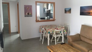 A living room with a brown sofa, a wooden coffee table, a dining table with chairs, a mirror, and two wall-mounted pictures. - SES SIVINES 3hab. PRIVATE POOL (Ciutadela)