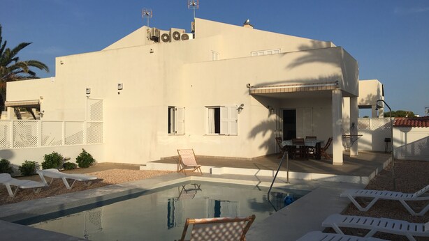 A modern building with a swimming pool, outdoor seating, and a covered patio area. - SES SIVINES 3hab. PRIVATE POOL (Ciutadela)