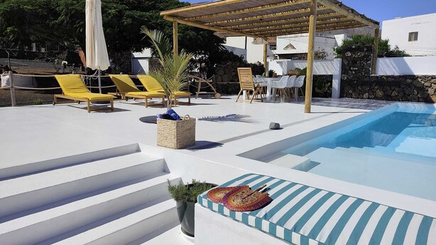 A pool area with a pergola, lounge chairs, and a small garden. -  Peace in the countryside 1 km from the beach, magnificent views, bbq and free wifi (Tabayesco)