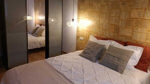 A bedroom with a bed, a mirror, and a wall covered with papers. -  Peace in the countryside 1 km from the beach, magnificent views, bbq and free wifi (Tabayesco)
