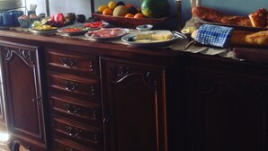 A dining table with various food items, a mirror, a clock, and a statue. - Charming wine maker house with generous surfaces, garden and pool in Languedoc (Murviel-Lès-Béziers)