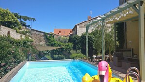A swimming pool with inflatable flamingos and a pergola with hanging lights. - Charming wine maker house with generous surfaces, garden and pool in Languedoc (Murviel-Lès-Béziers)