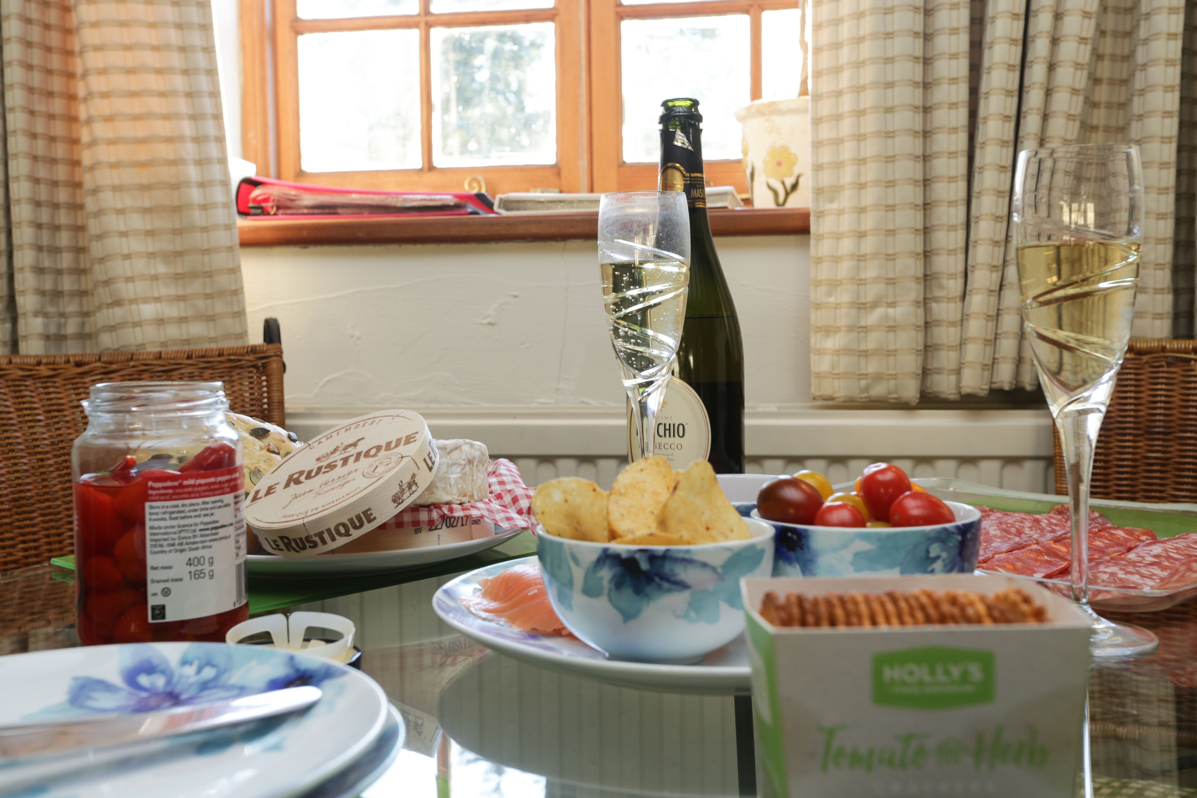 A table set with food, drinks, and a bottle of champagne.