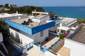 Ein modernes Gebäude mit Dachterrasse, Pool und Meerblick.