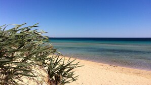 A beach with clear turquoise water and a sandy shore. - BLUE BAY HOUSE (Marina San Gregorio)