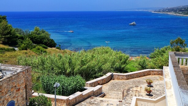 A coastal view with a stone pathway leading to a terrace with potted plants, overlooking the sea. - BLUE BAY HOUSE (Marina San Gregorio)