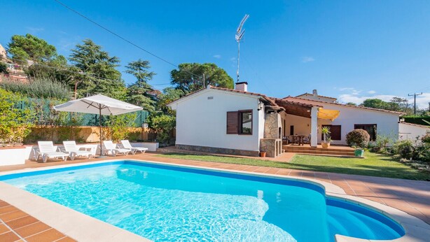 Una piscina amb gandules blanques i una zona de terrassa.