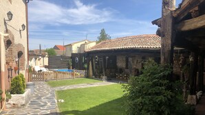A courtyard with a stone pathway, a small pool, and a wooden fence. - Self catering cottage Laguna Herrera for 14 people (Cuéllar)