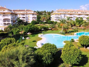 A resort with a large pool, lush greenery, and multi-story buildings. - RDR110 - Apt. Dama de Noche 6 (Marbella)