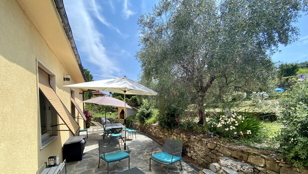 Patio esterno con pavimento in pietra, arredi da esterno e parete in pietra.
