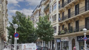 A street with buildings, a no parking sign, and a van with 'La Castellana' signage. - Always Easy I Kursaal (San Sebastián/Donostia)