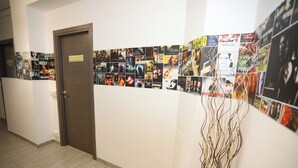 Ein Flur mit einem Schild 'FULL ROOM', einer Holztür und einer Wand, die mit Filmplakaten verziert ist.