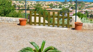 Une vue sur la côte, avec une clôture en bois, un pot de fleurs et un ciel dégagé.