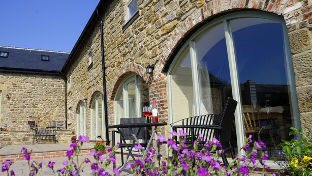 A stone building with large arched windows and outdoor seating. - Bowes Barn 4 Star near Beamish, Newcastle & Durham - Sleeps 3 -  Dogs Welcome  (Gateshead)