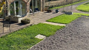 A stone building with a paved patio, outdoor seating, and a view of a rural landscape. - Bowes Barn 4 Star near Beamish, Newcastle & Durham - Sleeps 3 -  Dogs Welcome  (Gateshead)