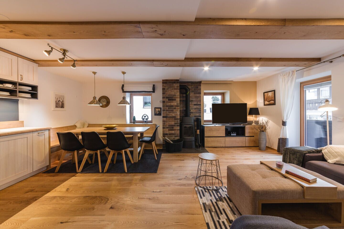 A modern living space with a kitchen, dining area, and seating area.