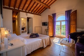 A bedroom with a bed, bedside table, and a small table with a bottle. - L'albero di Gamelì - Milena (Chiusi)
