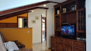 A living room with a wooden entertainment center, a television, and a sofa. - Apartment in Medulin with Seaview, Balcony, Air condition, WIFI (5216-6) (Medulin)