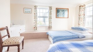 A bedroom with a bed, a chair, a window, and a painting on the wall. - Clovelly Cottage - Four Bedroom Cottage, Sleeps 8 (Crantock)