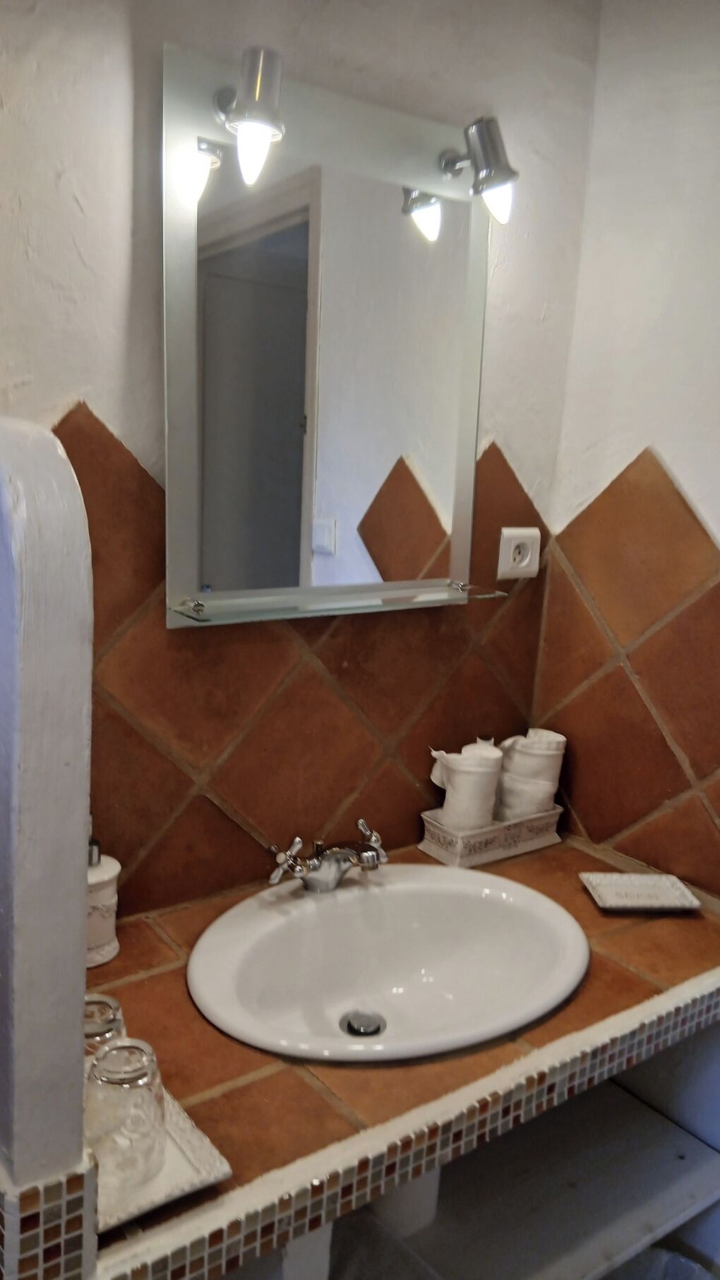 A bathroom with a white sink, a mirror, and a towel rack.