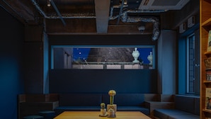 A cozy seating area with a wooden table, cushions, and a vase with flowers.