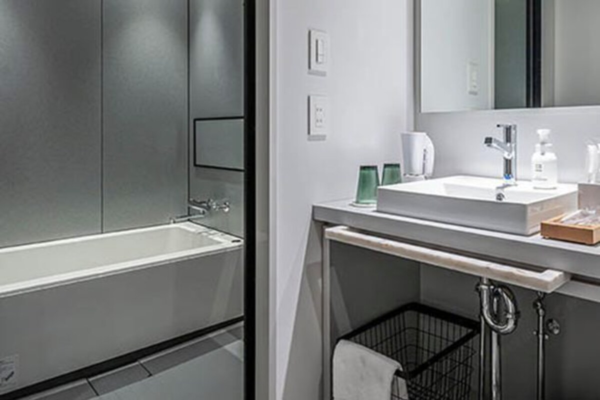 Un baño moderno con bañera, lavabo y espejo.