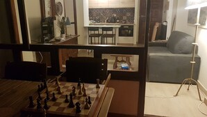 A living room with a chessboard, a sofa, and a lamp.