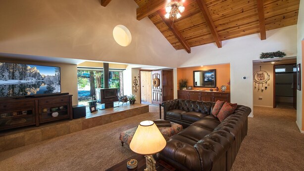 A spacious living area with a leather sofa, a wooden coffee table, and a television.