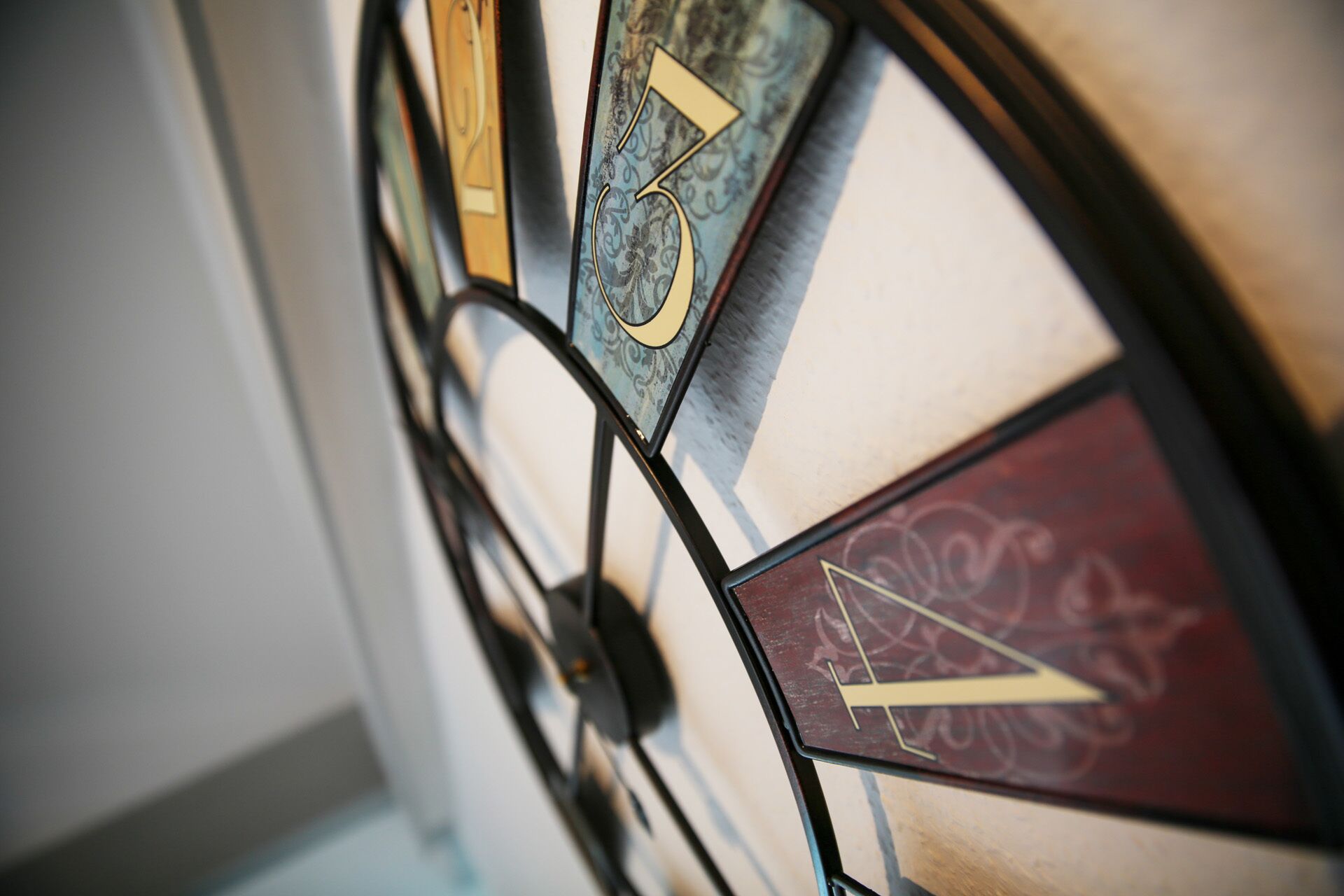 Primer plano de un reloj de vitral con números y detalles decorativos.
