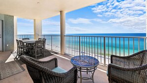 A balcony with wicker furniture, a table, and a view of the ocean. - 3BD/3BA Tower 3 Corner Renovated Condo! Comes with beach chairs and umbrella! (Panama City Beach)
