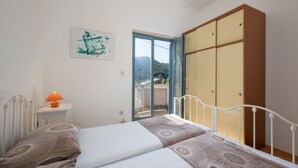 Une chambre à coucher avec un lit, une table de chevet, une lampe et une armoire.