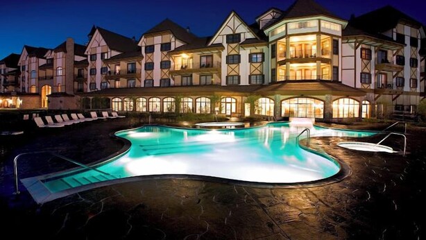 Un hotel grande con varias edificaciones, una piscina y zonas de descanso.