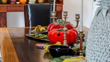 Een eettafel met verschillende gerechten, een ingelijst portret en een decoratieve lamp.
