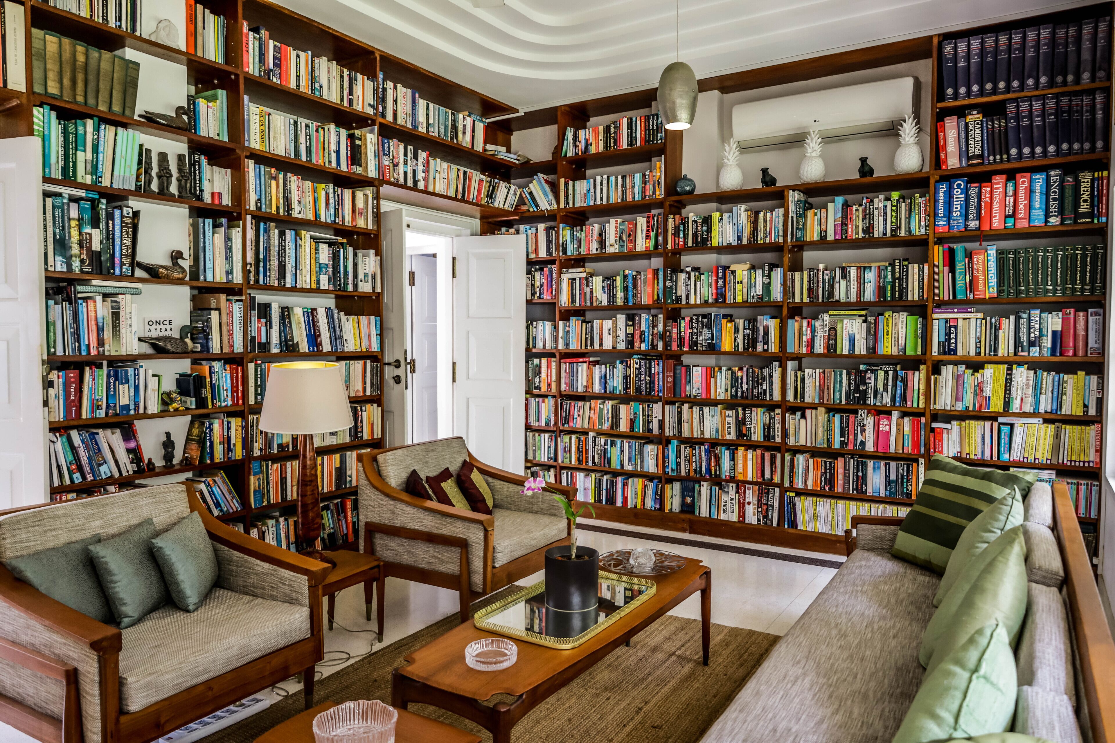 A cozy library with bookshelves, a sofa, and a coffee table.