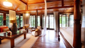 A spacious room with a wooden ceiling, large windows, and a bed with a white bedspread. - The Flame Tree Estate & Hotel (Galagedara)
