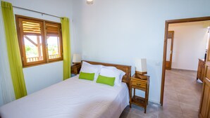 Una camera da letto con un letto, due comodini e una finestra con tende.