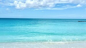 A beach with clear turquoise water and a sandy shore.