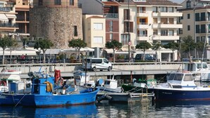 A marina with boats docked, a stone tower, and buildings with balconies. - Apartment for 4 people terrace sea view Cambrils beach 230m (Cambrils)