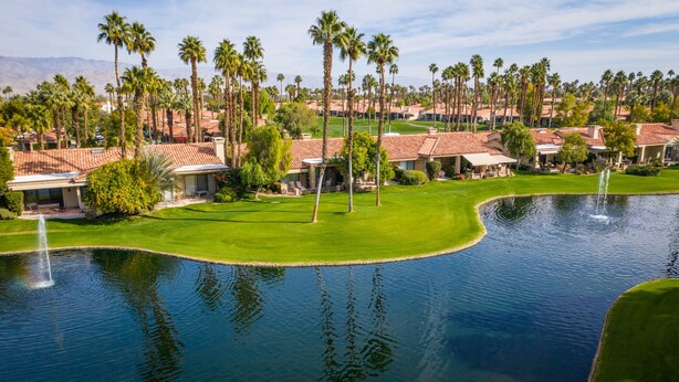 A golf course with a pond, palm trees, and houses with red-tiled roofs. - 
FUN IN SUN, GOLF&TEN.FEB-MARCH, PALM DESERT, PALM VALLEY CC. 55-Day Minimum
   (Palm Desert)