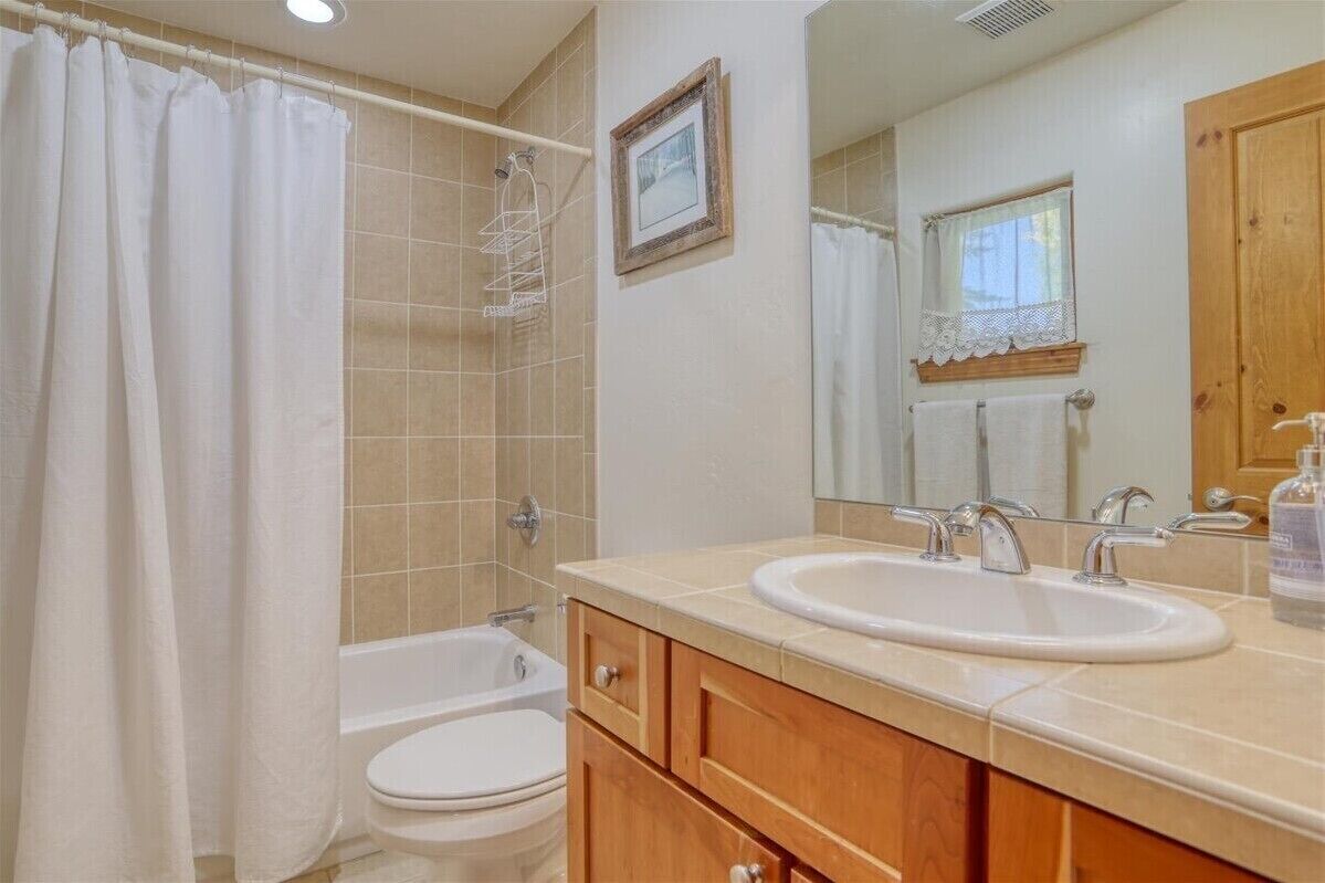 Un bagno con vasca, servizi igienici e lavandino con specchio.