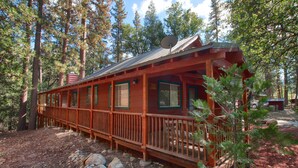 A cabin with a wooden deck, surrounded by trees. - (10N) Black Oak Lodge at The Redwoods In Yosemite (Yosemite National Park)