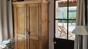 Un meuble en bois, une porte, une fenêtre, une lampe et une table.